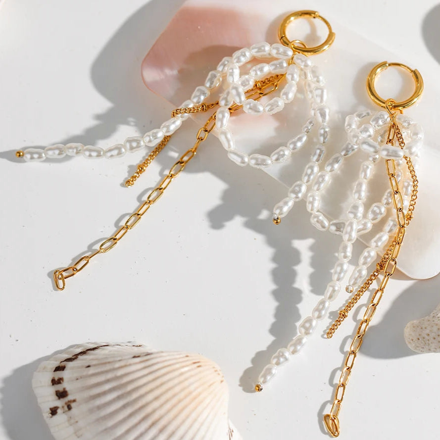 Gold and pearl necklace with seashells on a light background